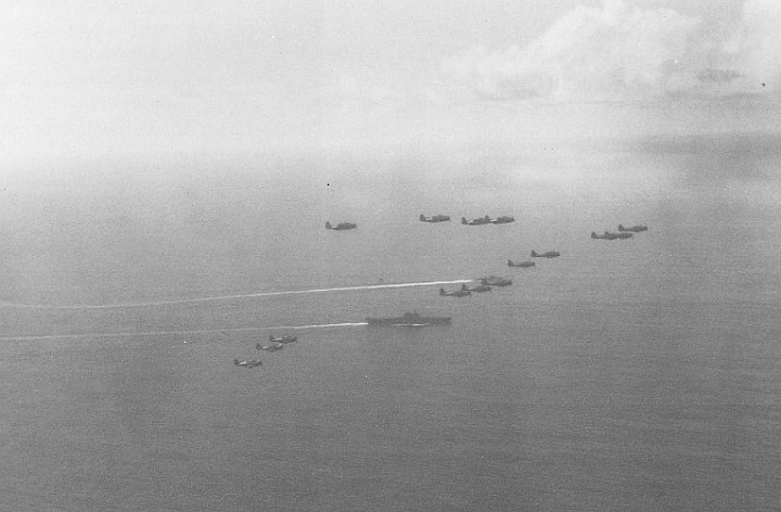 attack on palau-01.jpg - A strike group composed of TBF’s and SBD’s fly in formation above the USS Enterprise on their way to attack Palau.